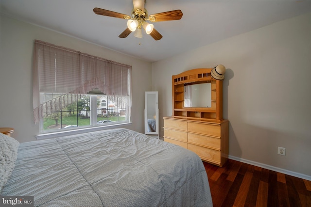 bedroom featuring wood finished floors, a ceiling fan, and baseboards