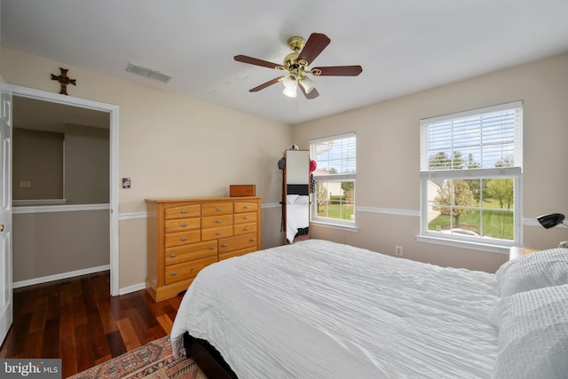 bedroom featuring wood finished floors, visible vents, baseboards, and ceiling fan