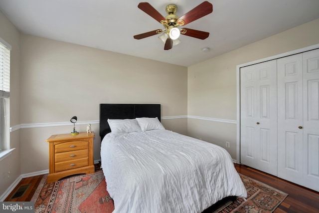 bedroom featuring wood finished floors, visible vents, a closet, baseboards, and ceiling fan