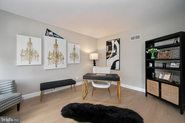 office featuring baseboards, wood finished floors, and visible vents