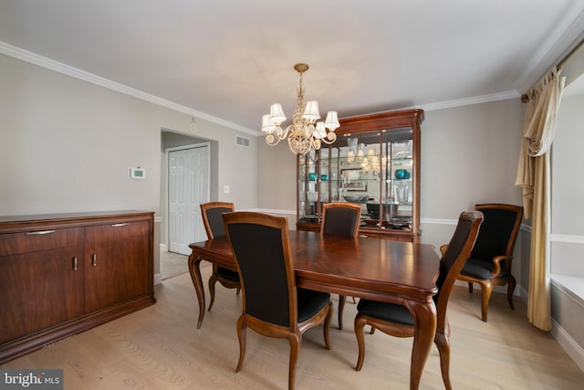 dining room with a chandelier, light wood-style flooring, visible vents, and ornamental molding