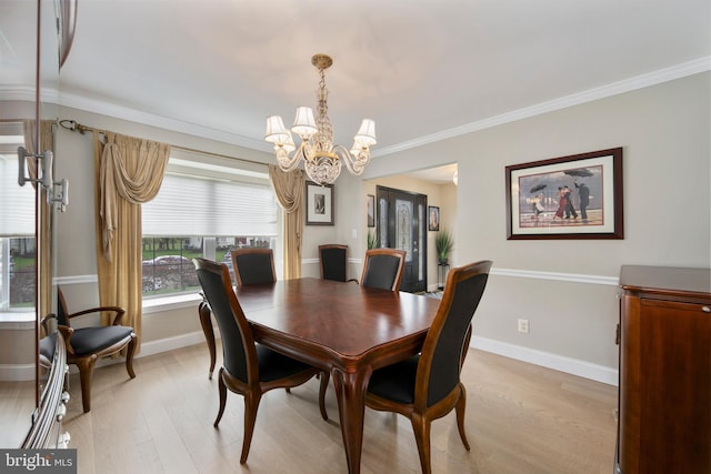 dining space featuring an inviting chandelier, ornamental molding, light wood-style floors, and baseboards
