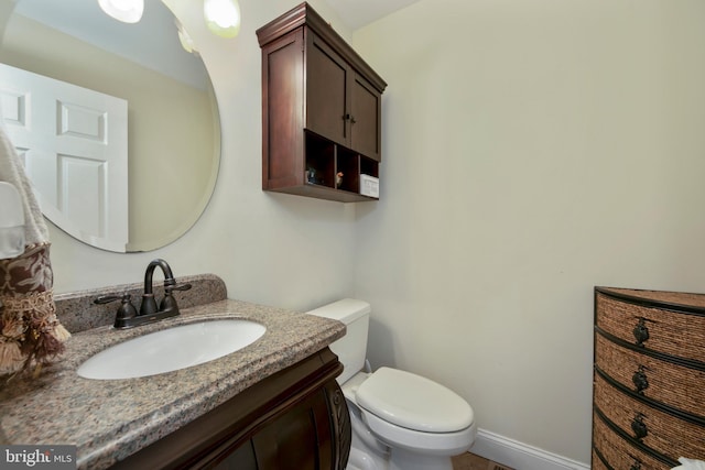 half bathroom with vanity and toilet