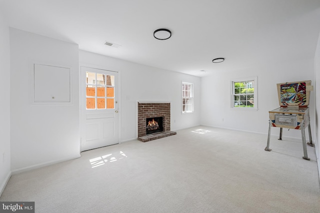 unfurnished living room with visible vents, baseboards, carpet flooring, and a fireplace