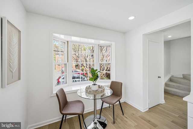 dining area with a wealth of natural light, light wood finished floors, and baseboards
