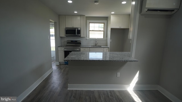 3220 Byberry Rd, Philadelphia, PA 19154 - kitchen featuring appliances with stainless steel finishes, a wall mounted air conditioner, a sink, baseboards, and light stone counters