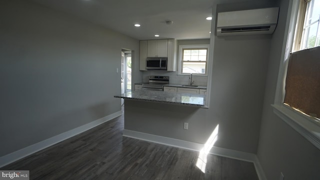 3220 Byberry Rd, Philadelphia, PA 19154 - kitchen featuring stainless steel appliances, a wall mounted air conditioner, a sink, white cabinetry, and light stone countertops