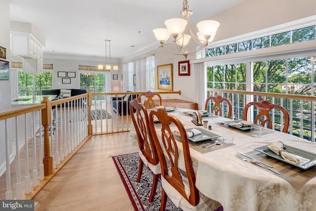 dining space with light wood-style flooring and a notable chandelier