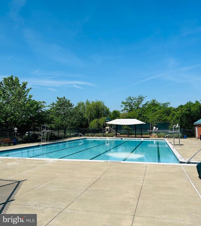 pool featuring fence and a patio