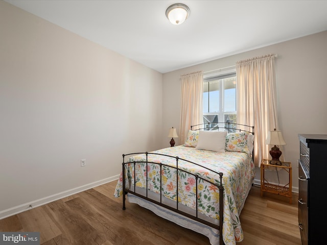 bedroom featuring wood finished floors and baseboards