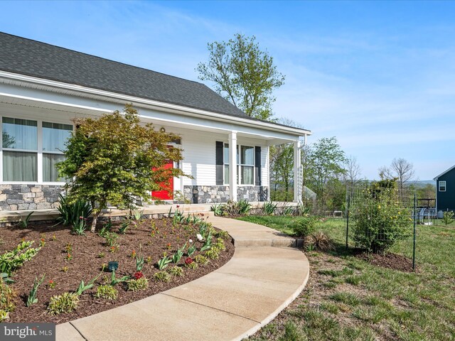 entrance to property featuring stone siding and covered porch