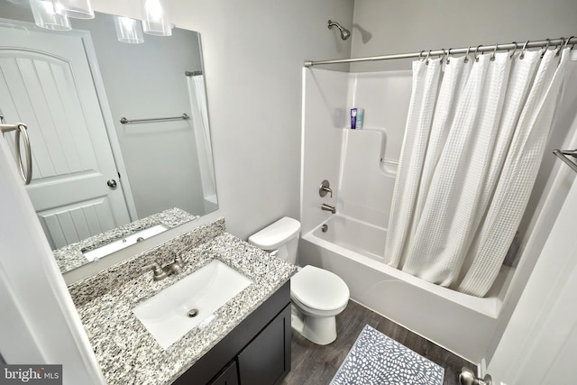 full bath with shower / tub combo, toilet, wood finished floors, and vanity