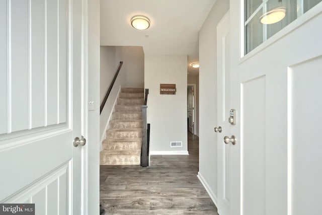 entryway featuring visible vents, stairway, wood finished floors, and baseboards