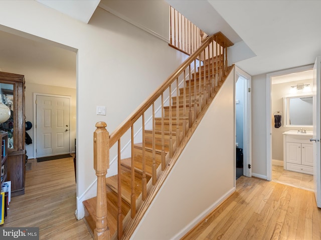 staircase featuring baseboards and wood finished floors
