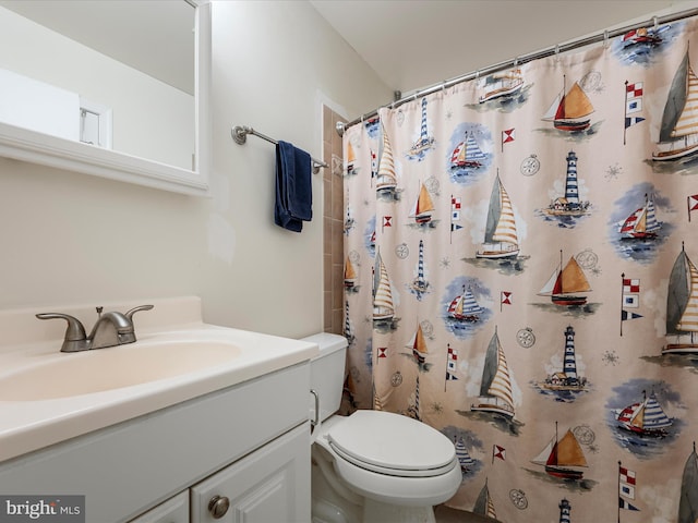 bathroom featuring a shower with shower curtain, toilet, and vanity