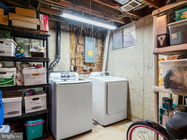 laundry room featuring electric panel, washer and dryer, and laundry area