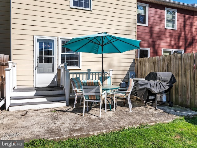 view of patio featuring grilling area, outdoor dining area, and fence