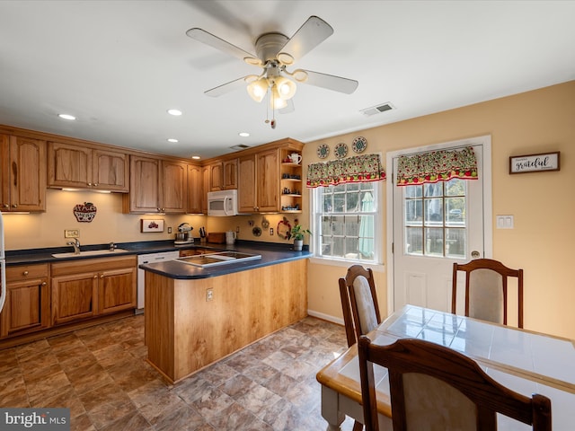 kitchen featuring dark countertops, visible vents, white microwave, open shelves, and dishwasher