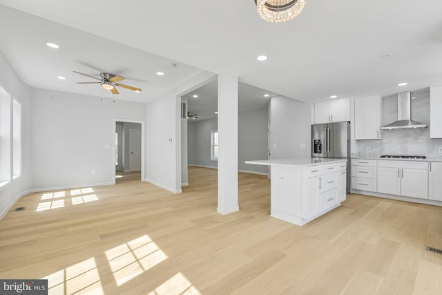 5634 6th St N, Arlington, VA 22205 - kitchen featuring wall chimney exhaust hood, a kitchen island, ceiling fan, light countertops, and decorative backsplash
