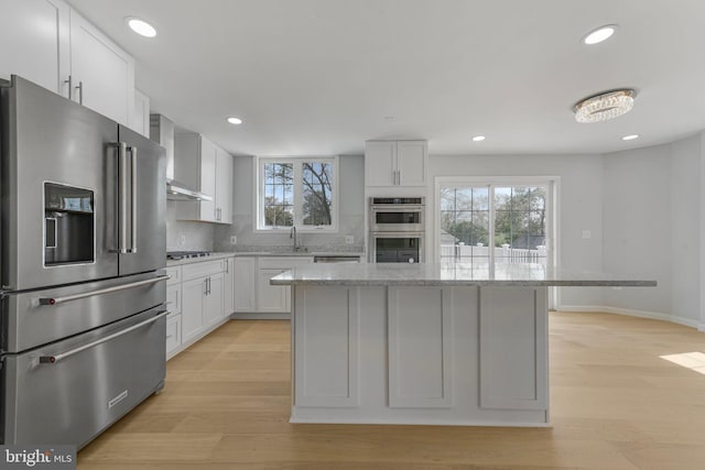 5634 6th St N, Arlington, VA 22205 - kitchen with appliances with stainless steel finishes, light wood-style floors, a sink, recessed lighting, and white cabinets