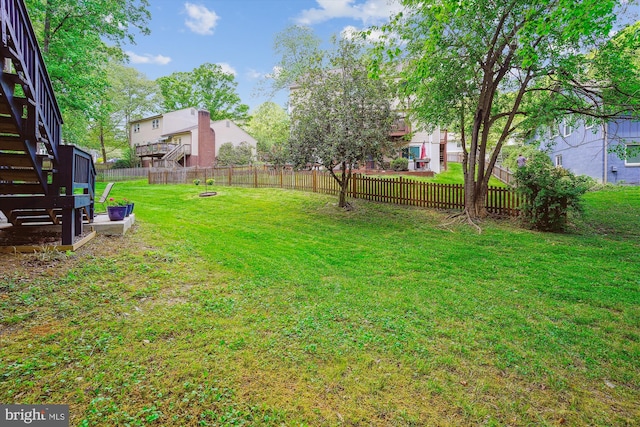view of yard with a fenced backyard and stairway
