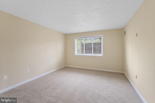 unfurnished room featuring a textured ceiling, visible vents, carpet floors, and baseboards