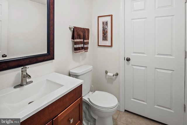 half bath featuring vanity, tile patterned floors, and toilet