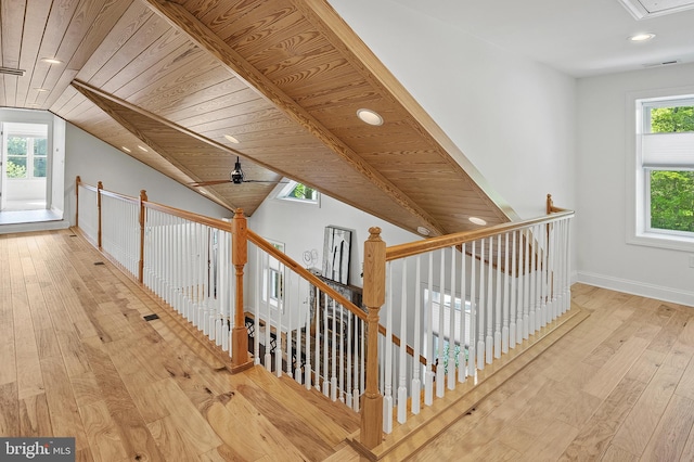 interior space featuring wood ceiling, lofted ceiling, hardwood / wood-style flooring, and an upstairs landing