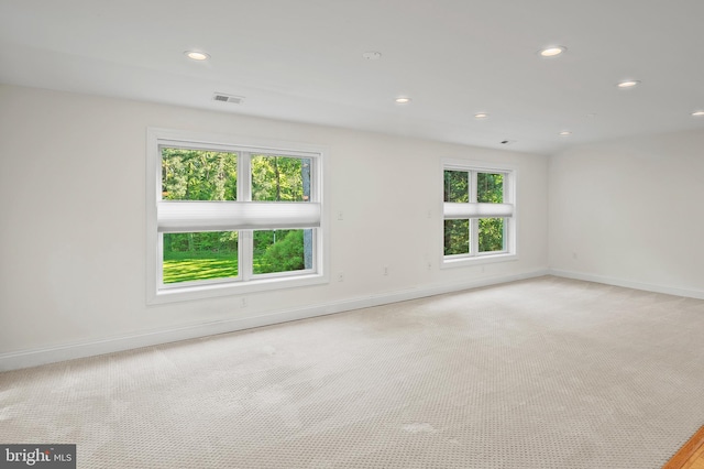 carpeted spare room featuring recessed lighting, baseboards, and visible vents