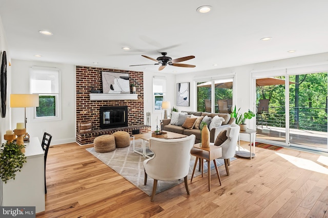 living room with recessed lighting, a ceiling fan, wood finished floors, and a fireplace