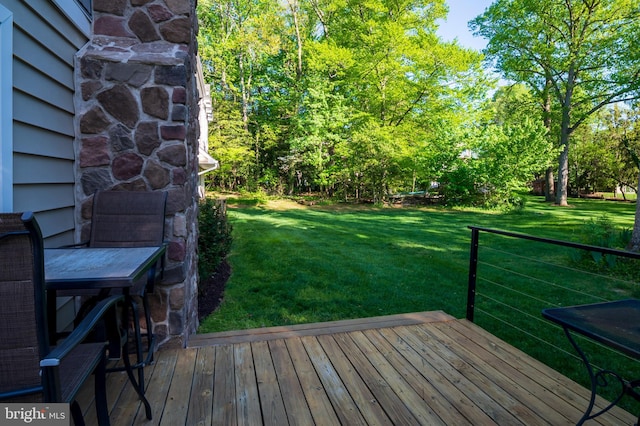wooden terrace featuring a yard