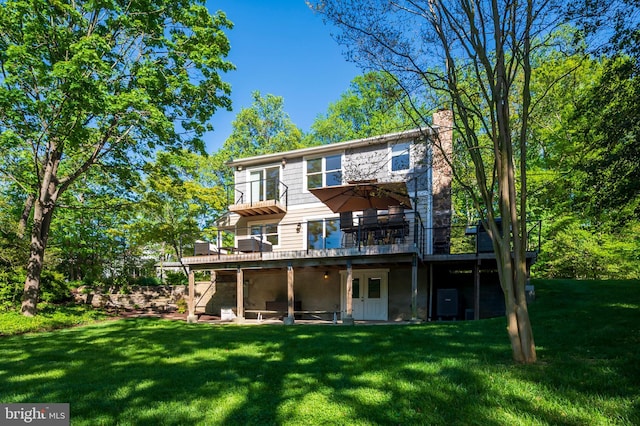 back of property featuring a lawn, a wooden deck, and a chimney