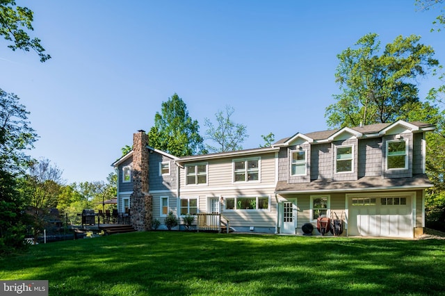 back of house with a lawn, an attached garage, a wooden deck, and a chimney