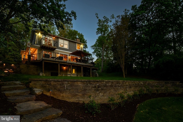 rear view of house featuring a yard, a chimney, and a wooden deck