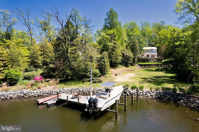 view of dock with a lawn, a water view, and a view of trees