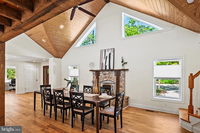 dining area featuring light wood finished floors, high vaulted ceiling, wooden ceiling, and stairway