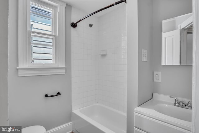 bathroom featuring shower / washtub combination, vanity, toilet, and a wealth of natural light