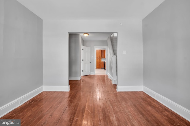 spare room with wood-type flooring and baseboards