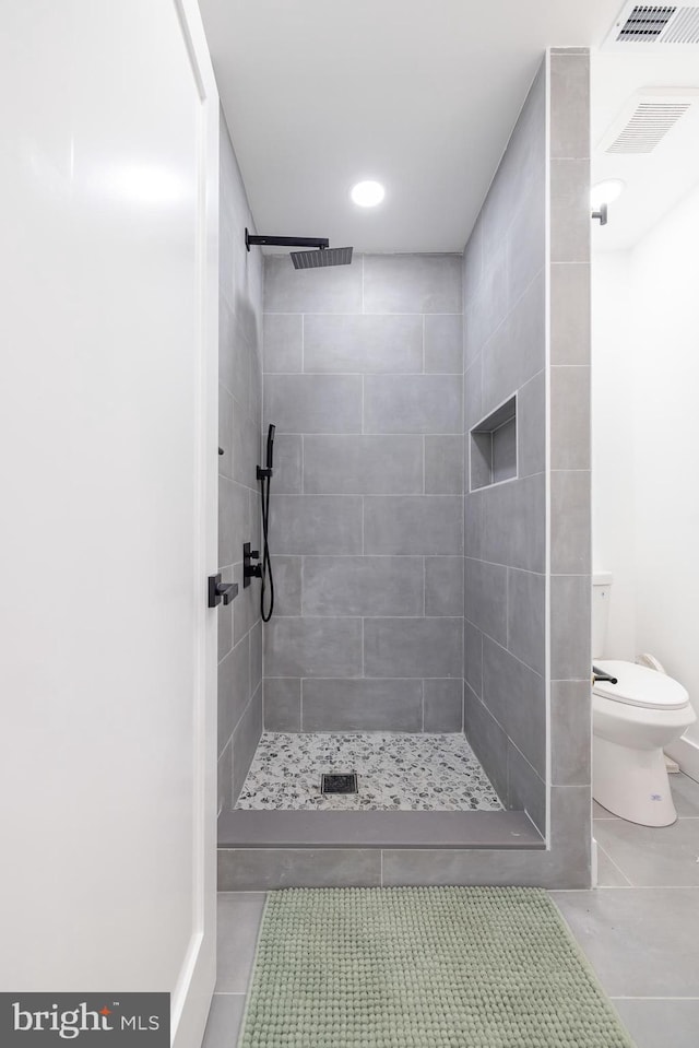 2475 W Denneys Rd, Dover, DE 19904 - bathroom with toilet, tile patterned flooring, visible vents, and tiled shower