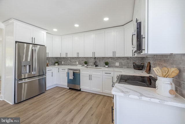 2475 W Denneys Rd, Dover, DE 19904 - kitchen with white cabinets, stainless steel appliances, a sink, light wood-style floors, and light stone countertops