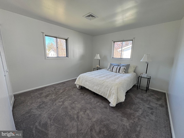 bedroom with baseboards, visible vents, and dark carpet