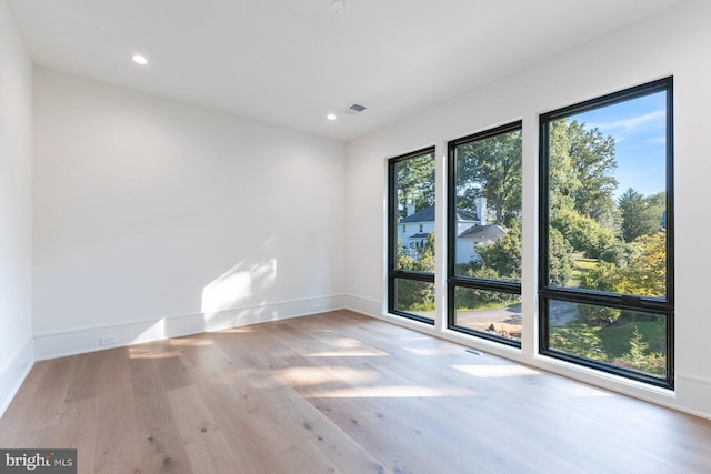 spare room featuring visible vents, baseboards, wood finished floors, and recessed lighting