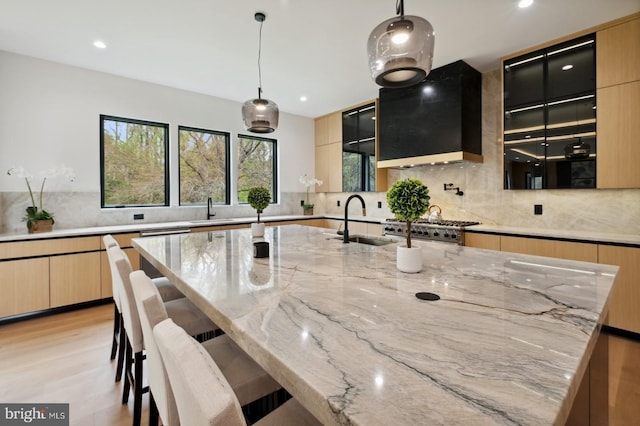 kitchen with modern cabinets, a sink, and custom range hood