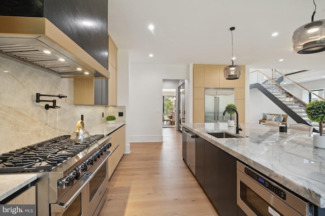 kitchen featuring built in appliances, modern cabinets, a sink, decorative backsplash, and custom exhaust hood