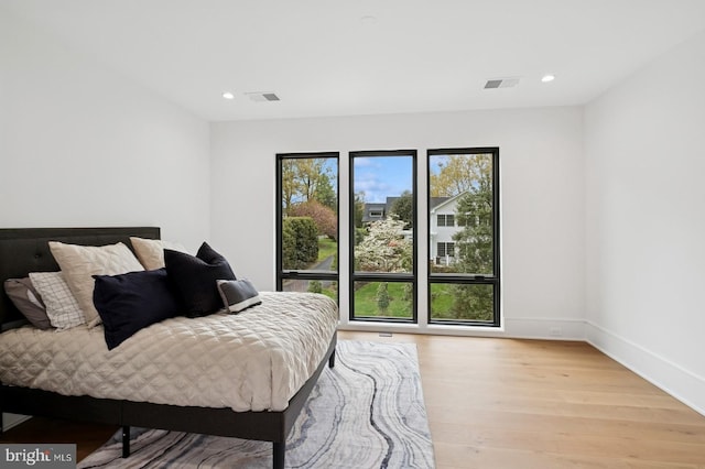 bedroom featuring visible vents, baseboards, wood finished floors, and recessed lighting