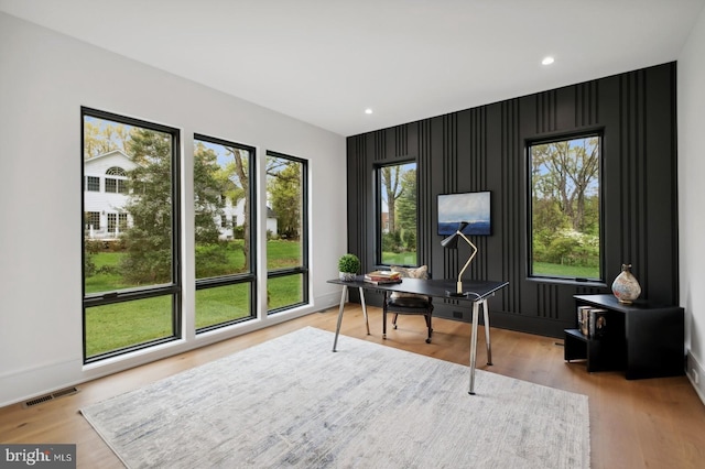 home office with recessed lighting, an accent wall, wood finished floors, and visible vents