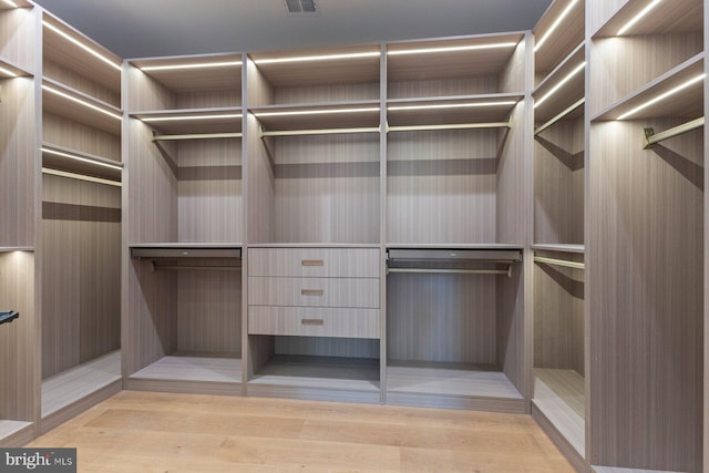 walk in closet featuring light wood-type flooring and visible vents