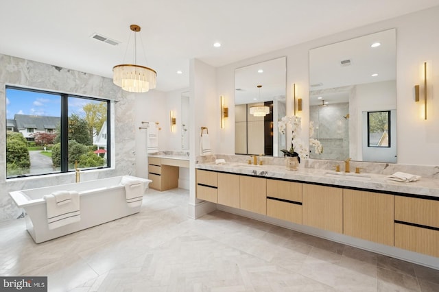 bathroom featuring a stall shower, an inviting chandelier, a soaking tub, double vanity, and visible vents