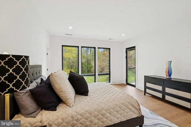 bedroom featuring wood finished floors, visible vents, recessed lighting, and access to exterior