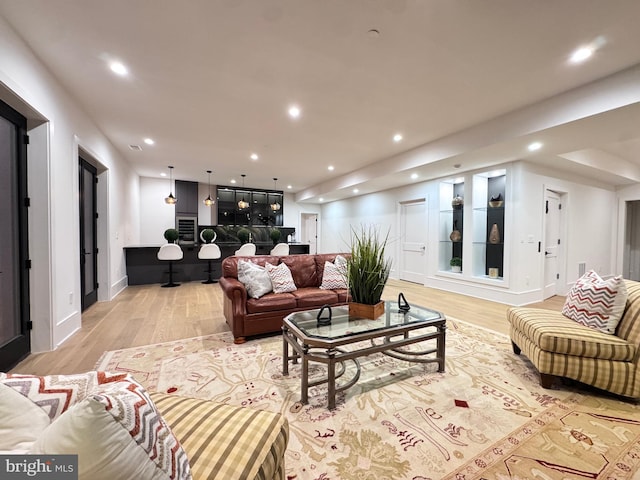 living area with baseboards, light wood-style floors, and recessed lighting